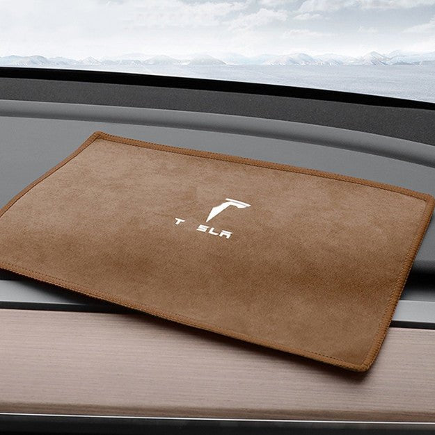Brown smooth face of the microfiber towel laid on a car dashboard