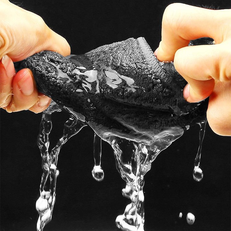 Hands wringing water from the grey plush side of the microfiber towel