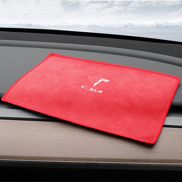 Red smooth face of the microfiber towel laid on a car dashboard