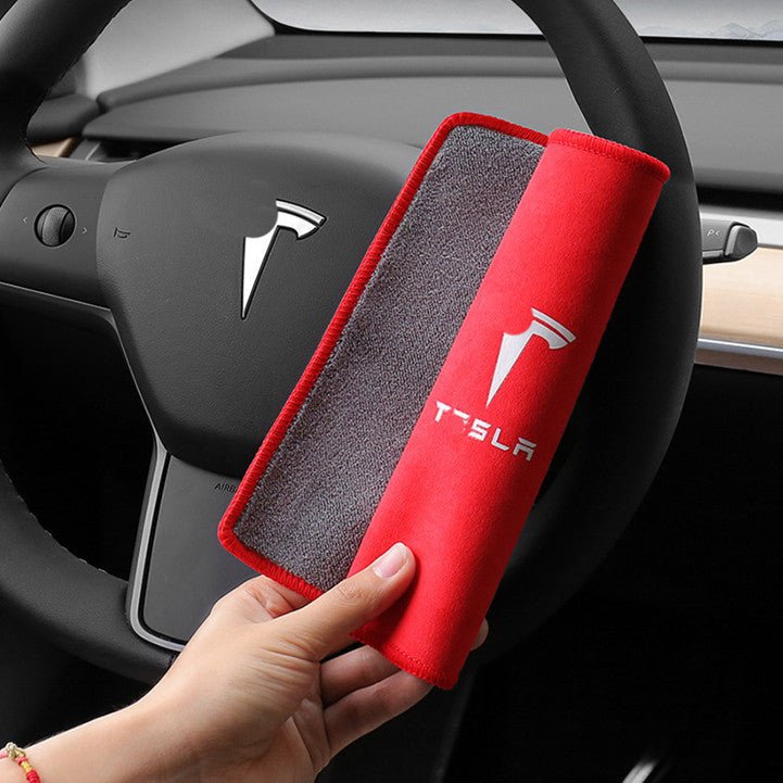 Grey plush face of a red-edged dual-sided microfiber car towel with moisture on the fabric